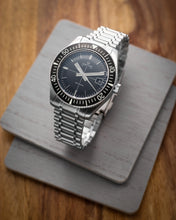 Load image into Gallery viewer, Silver watch with a black face on a wooden surface
